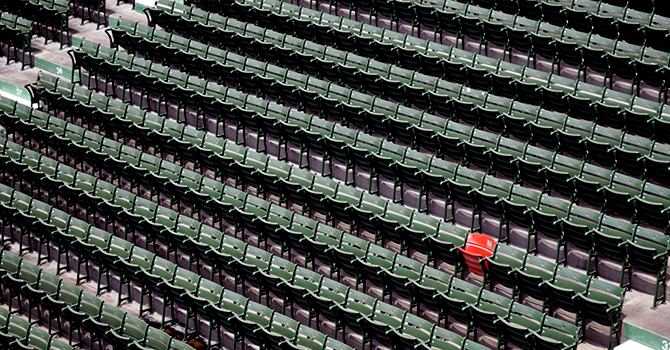 An empty sports arena and lone red seat