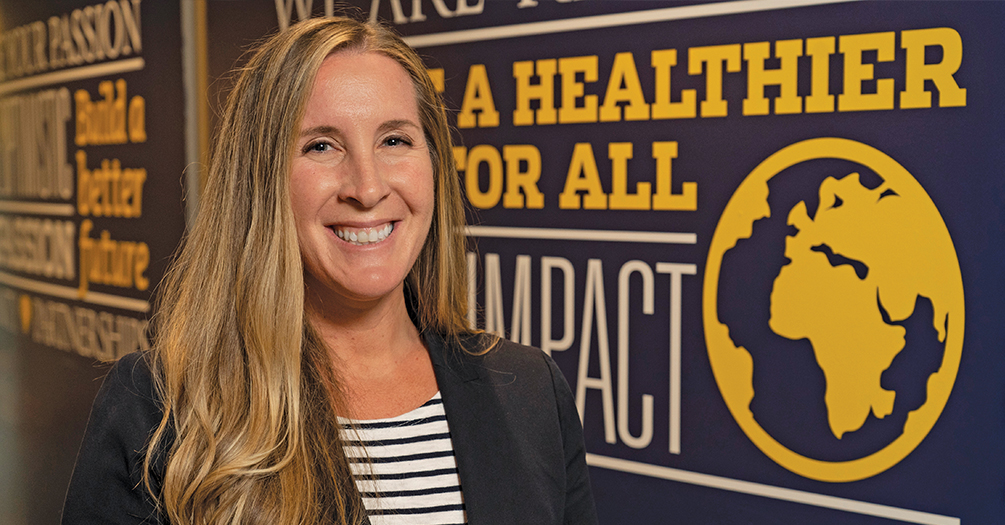 image of tara smiling in front of public health banner