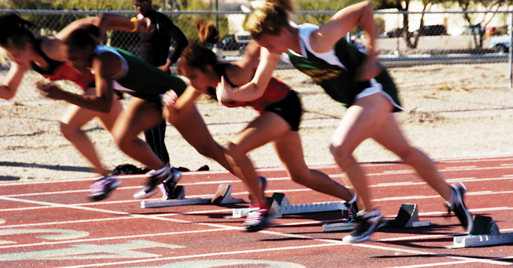 Female track runners leave the starting blocks
