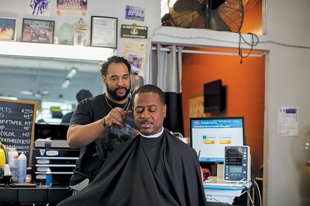 Eric Mohammad, barber, and Mark Sims in barber chair.
