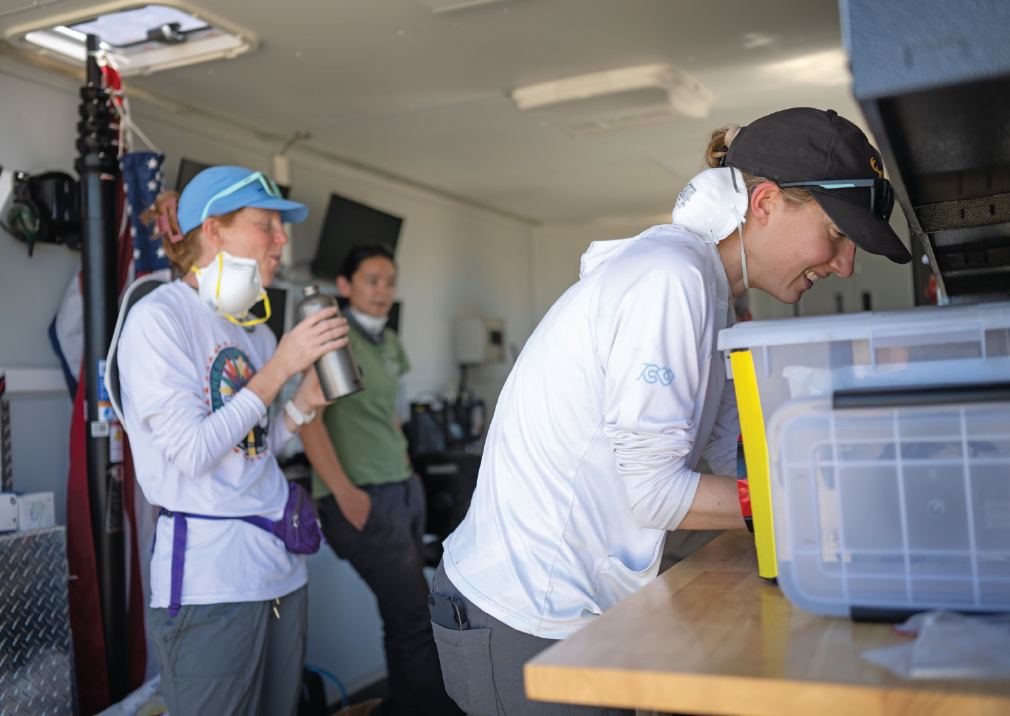 After each air sample is collected, air filters are extracted from their sampler within a portable, sterile glovebox and are moved into a storage tube until they can be analyzed for Coccidioides. From left, Jennifer Head, Kalia Bistolas of the US Environmental Protection Agency, and postdoctoral scholar Lisa Couper of UC Berkeley.