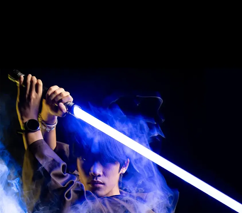 Owen Chun poses with Jedi garb and a blue lightsaber