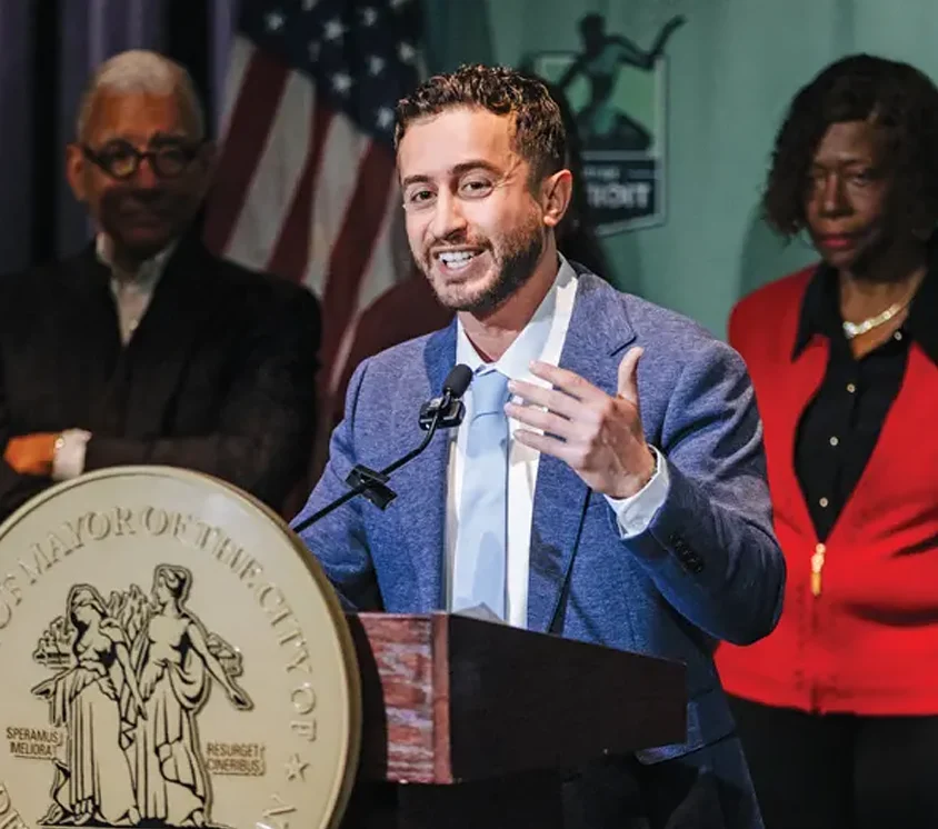 Ali Abazeed at the podium during the news conference announcing his hiring with four people in the background
