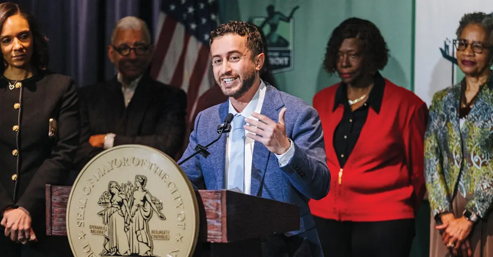 Ali Abazeed at the podium during the news conference announcing his hiring with four people in the background