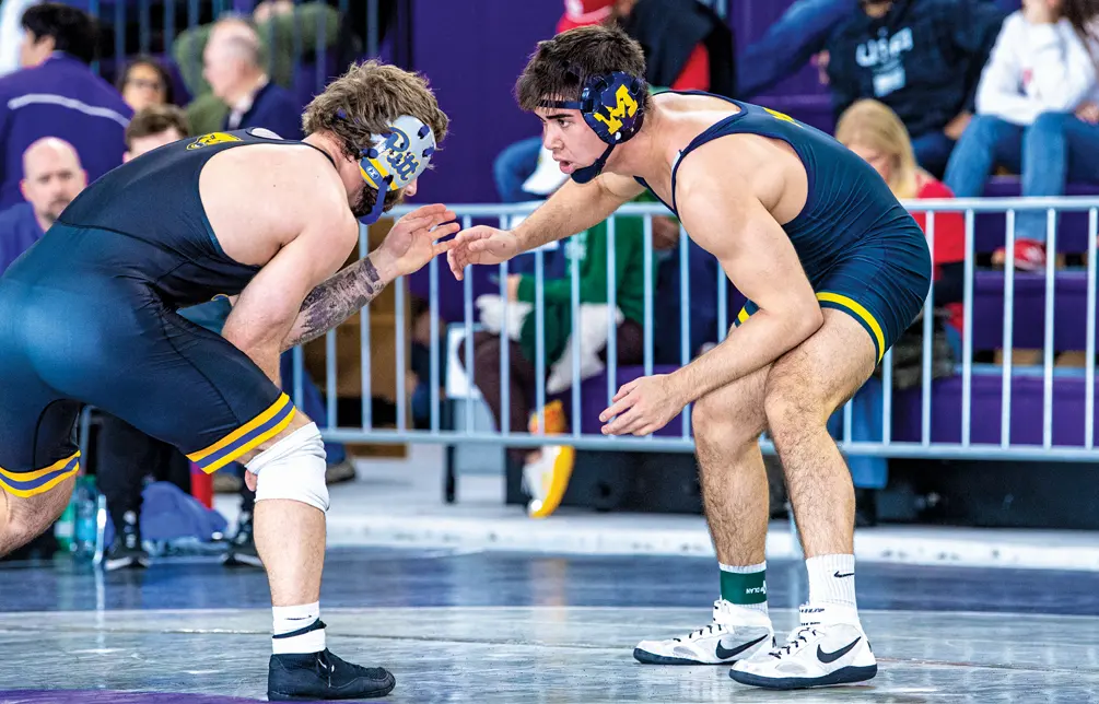 Michigan wrestler Josh Knudten, right, faces off against an opponent on the mat