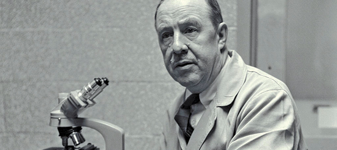 Thomas Francis Jr. at a microscope in the University of Michigan School of Public Health