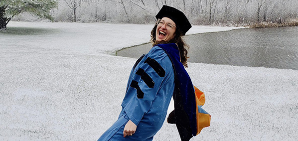 student celebrating graduation in the snow