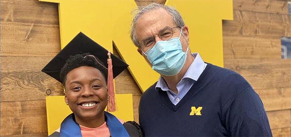 graduating student with UM President Schlissel
