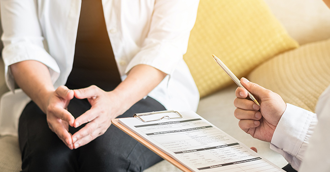 Woman sitting with a doctor.