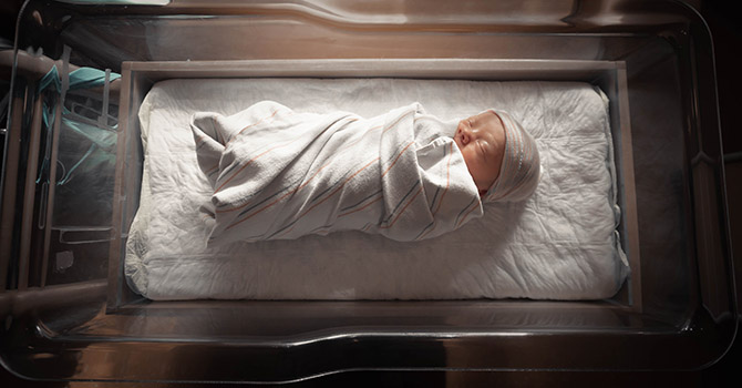 Newborn in a bassinet at a hospital.