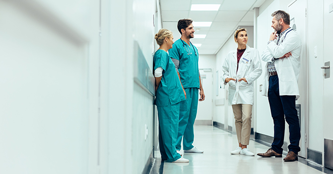 Medical professionals standing in a hospital hallway.