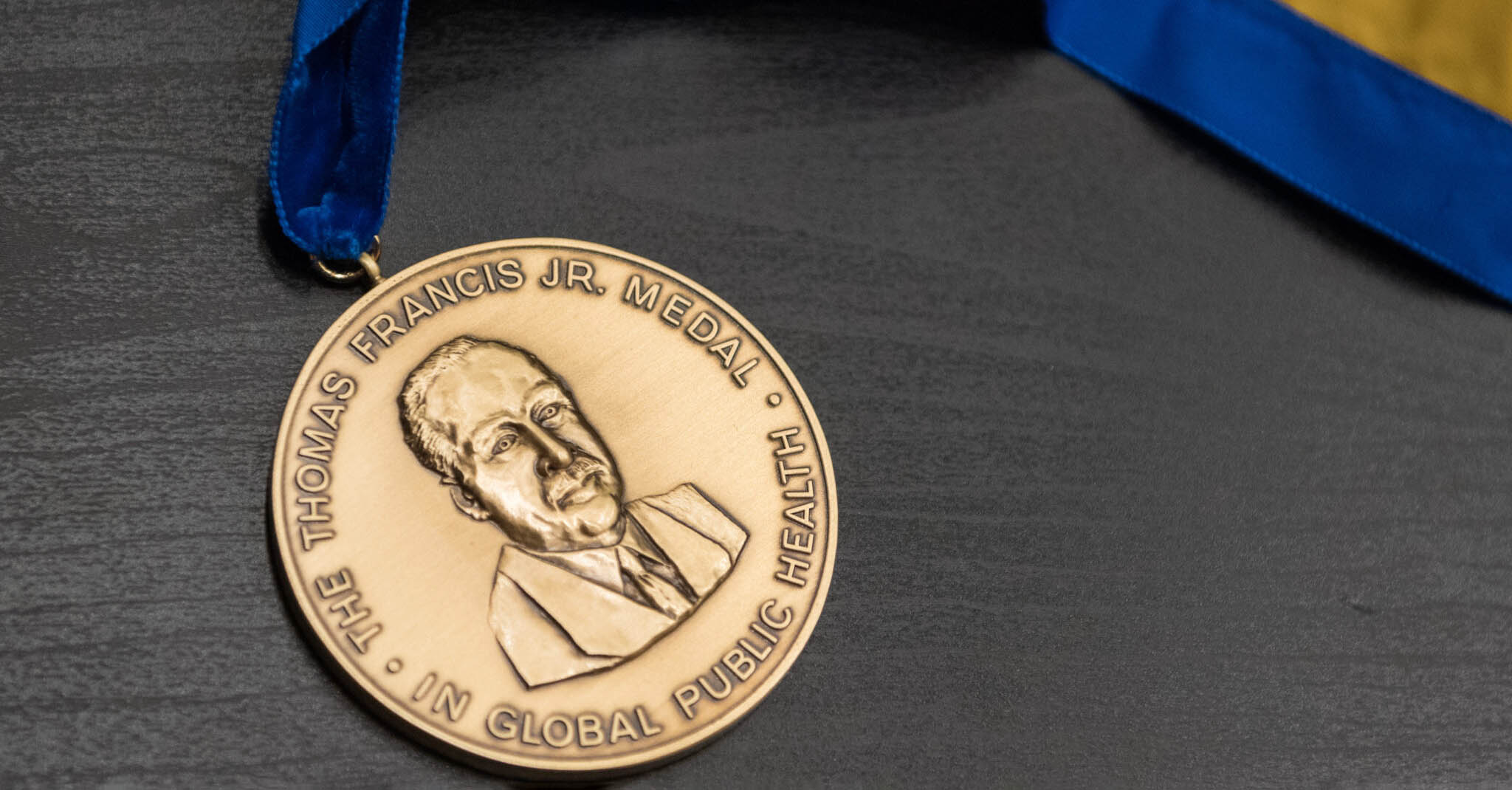 The Thomas Francis Jr. Medal sits on a wood desk.