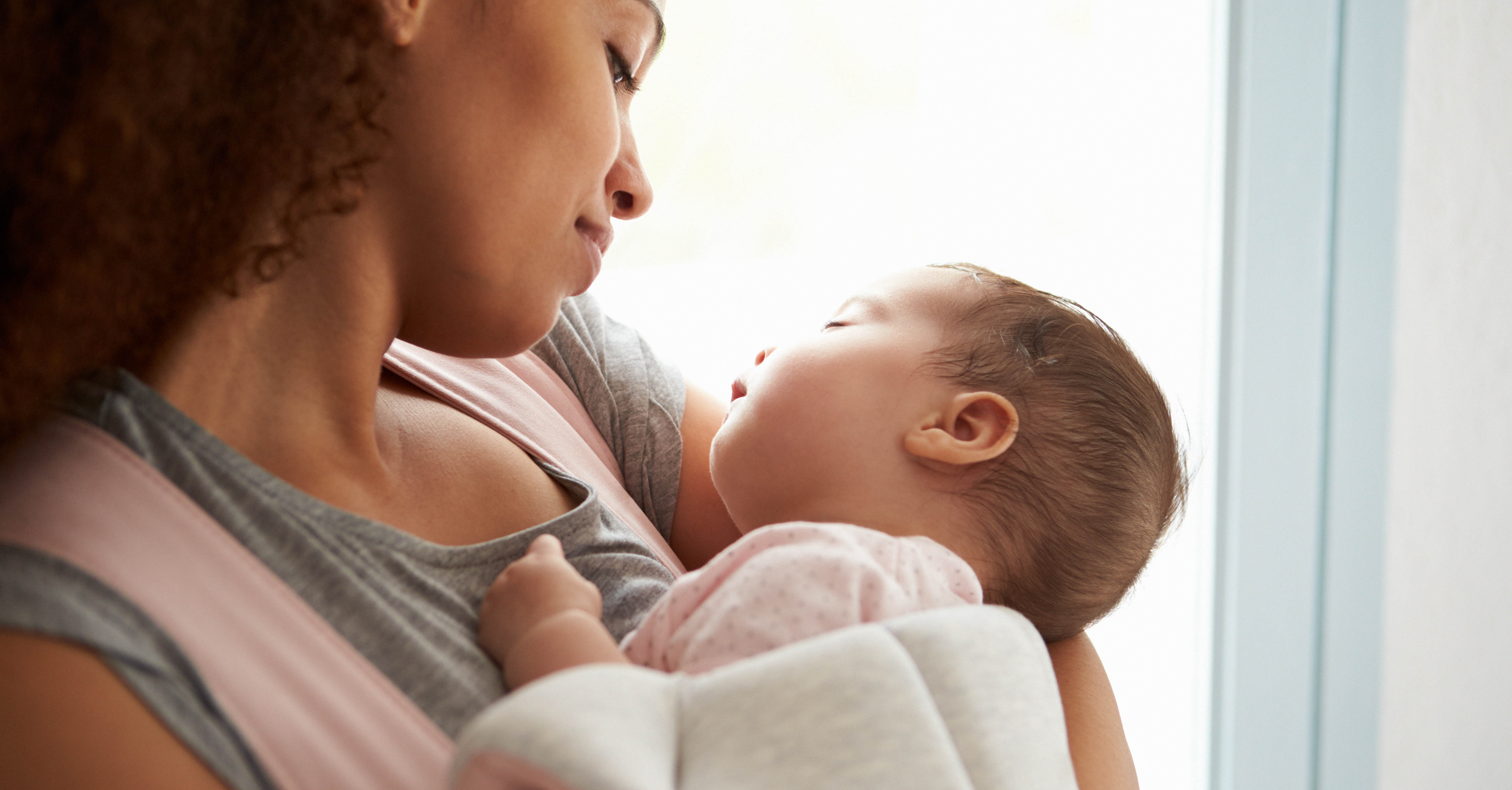 A woman holding a sleeping baby