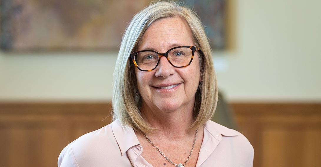 Headshot of Paula Lantz, wearing tortoise shell cat-eye glasses and a light pink top.