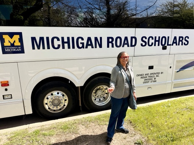 Devon Payne-Sturges stands in front of the Michigan Road Scholars bus.