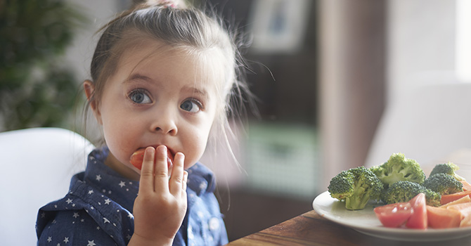 Young child eating vegetables