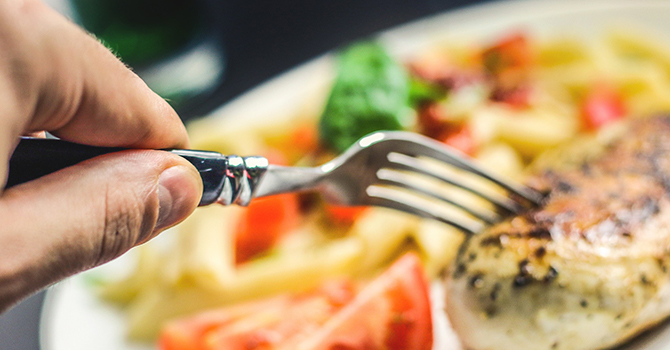 eating chicken breast with fork