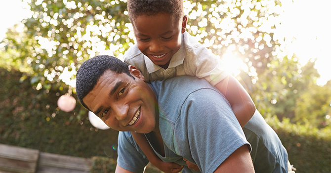 A father plays outside with his young son