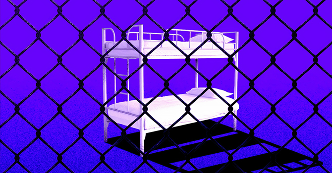 Bunk beds viewed through chain-link fence