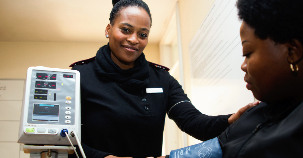 Health care worker taking a patient's blood pressure in a clinic