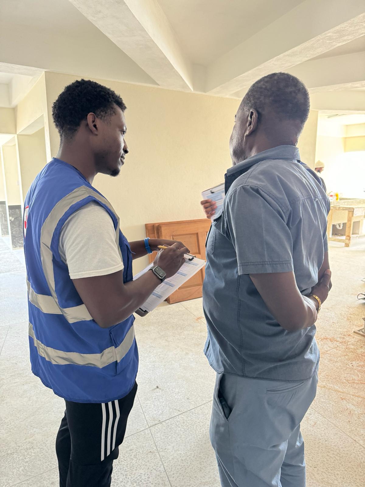 Caption: Darius Moore conducting a community survey with a local construction worker. 