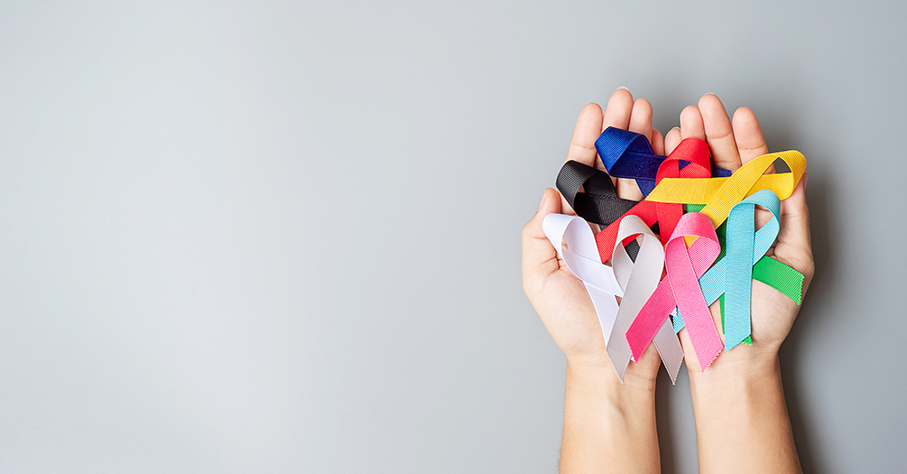 hands holding various cancer ribbons