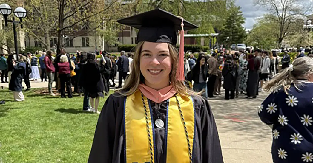 Paige Jewell, with her cap and gown on after graduation, on the Ann Arbor campus